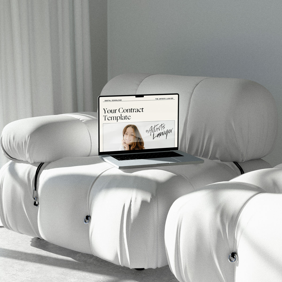 Laptop on white couch, showcasing an artist contract template.